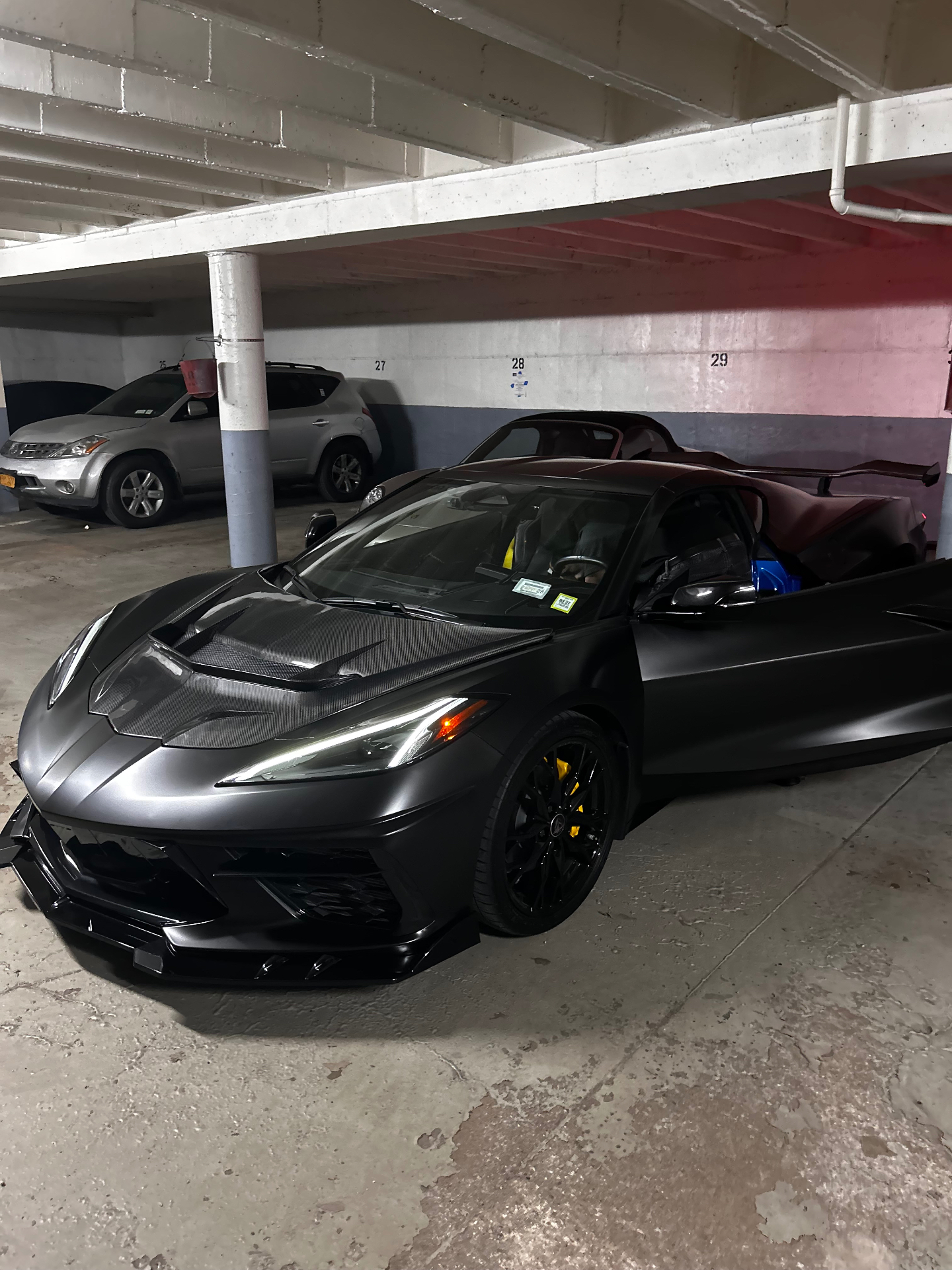 Satin black Corvette C8 with carbon fiber hood and yellow calipers