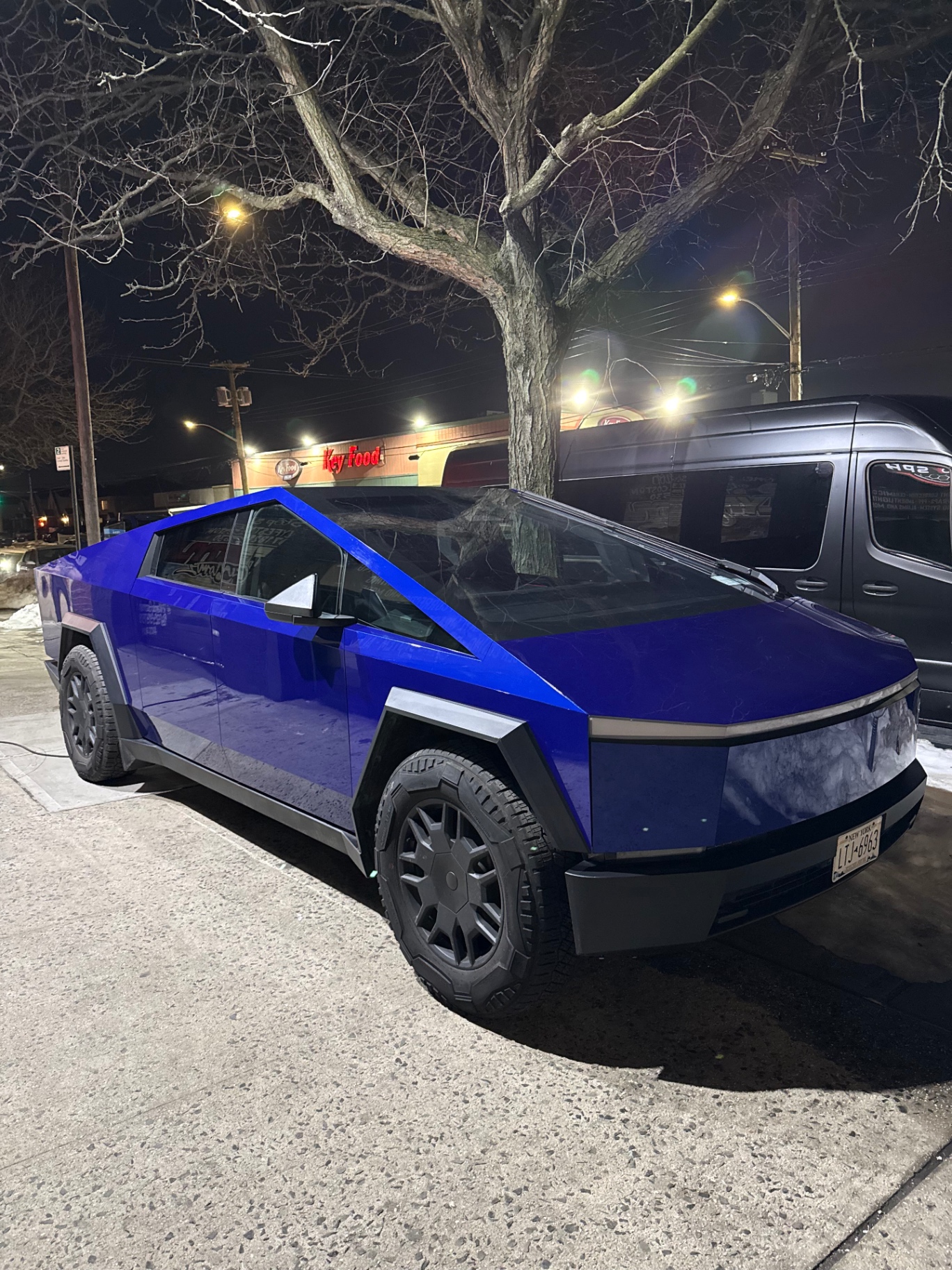 Electric blue wrapped Tesla Cybertruck at night in Queens