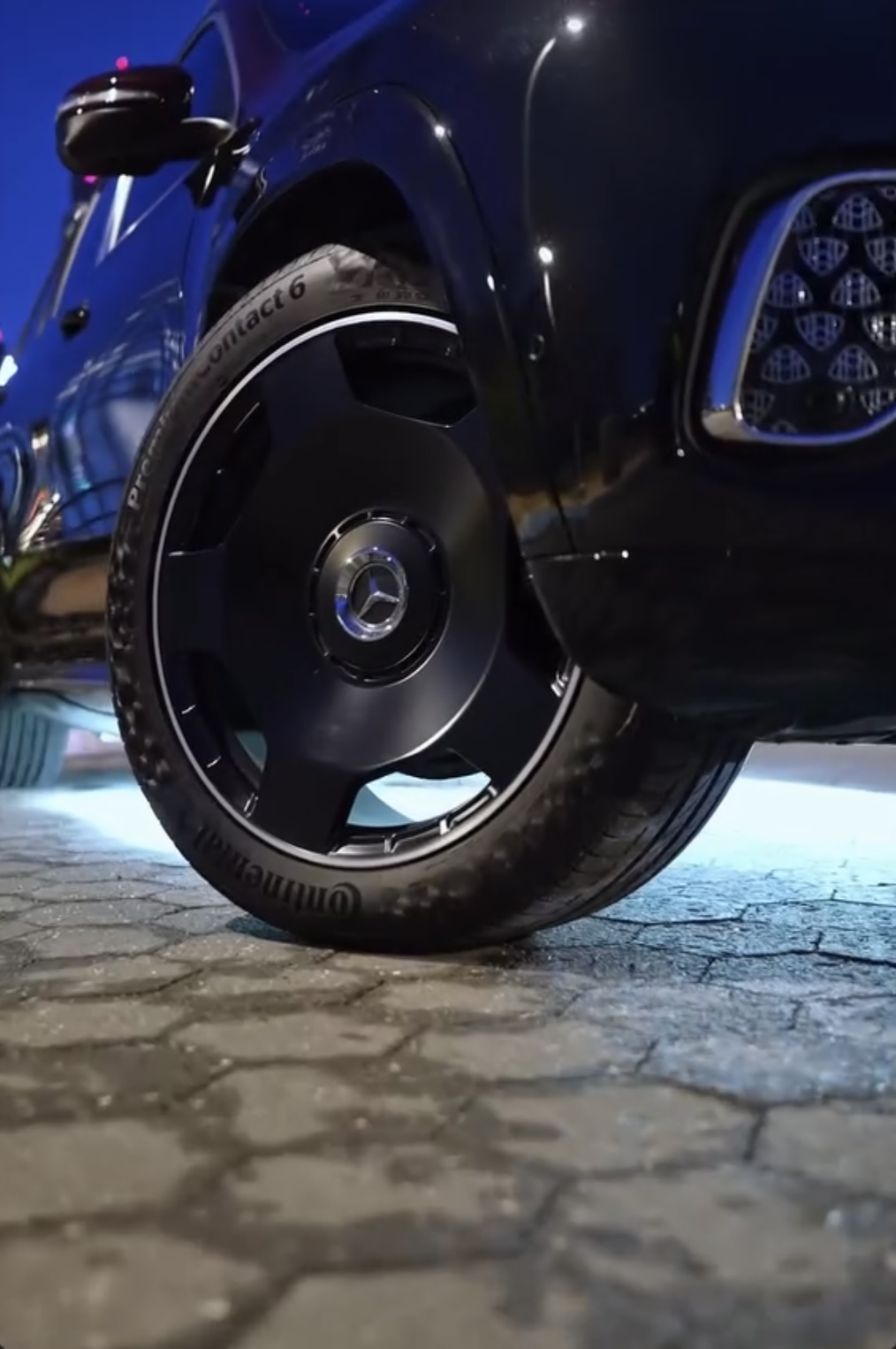 Gloss black Mercedes wheel close up with ambient lighting